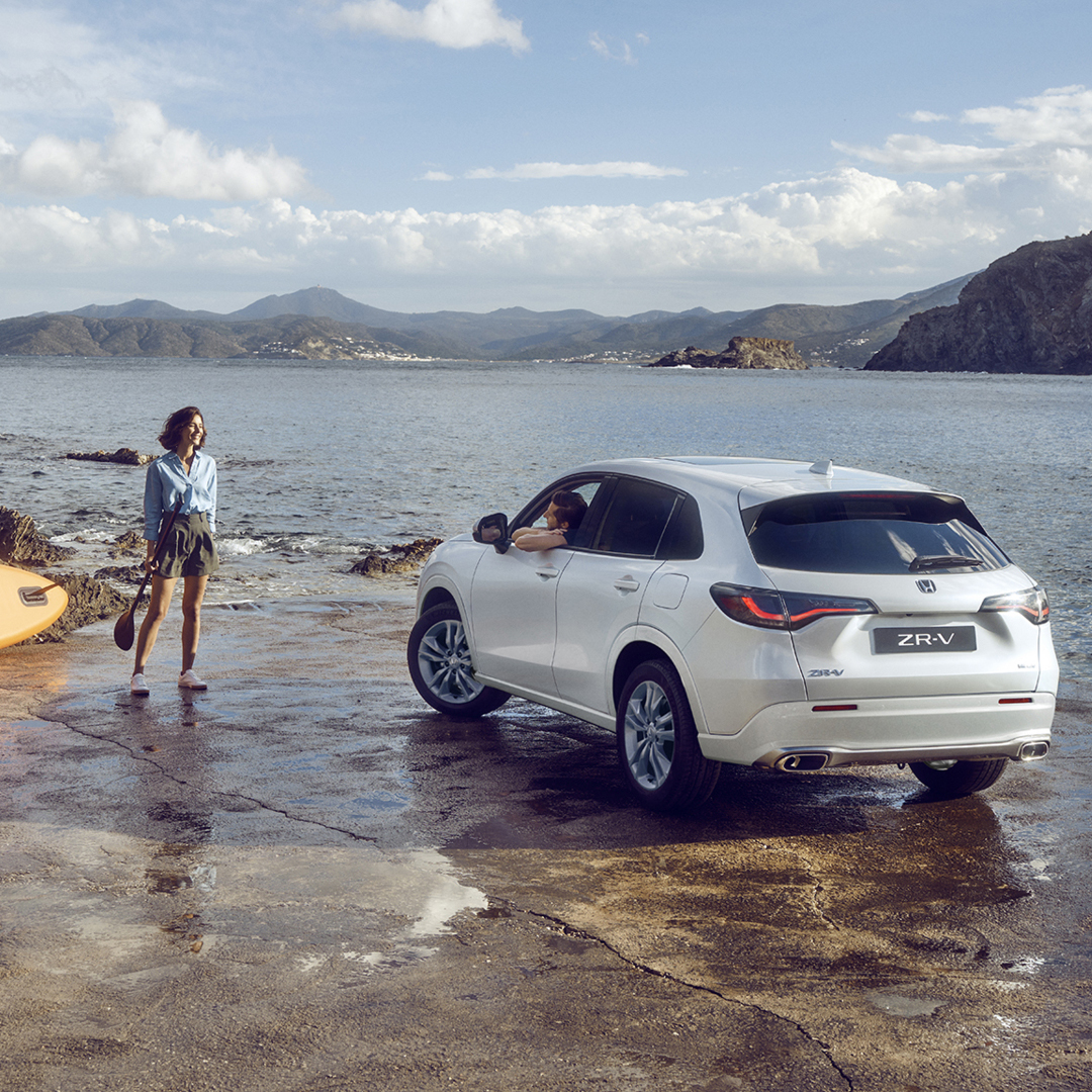 ZR-V blanco en la costa con mujer y canoa