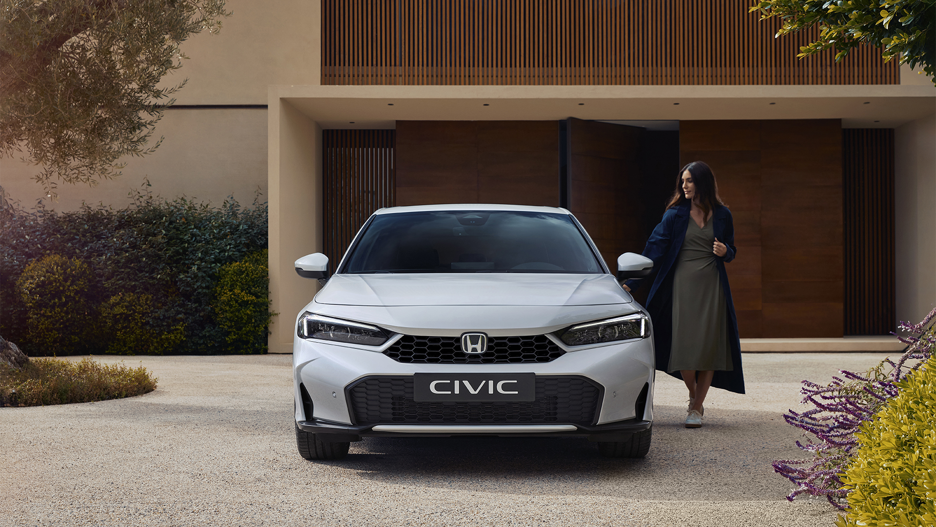 Fotografía frontal de un Civic Hybrid, con una mujer abriendo la puerta.