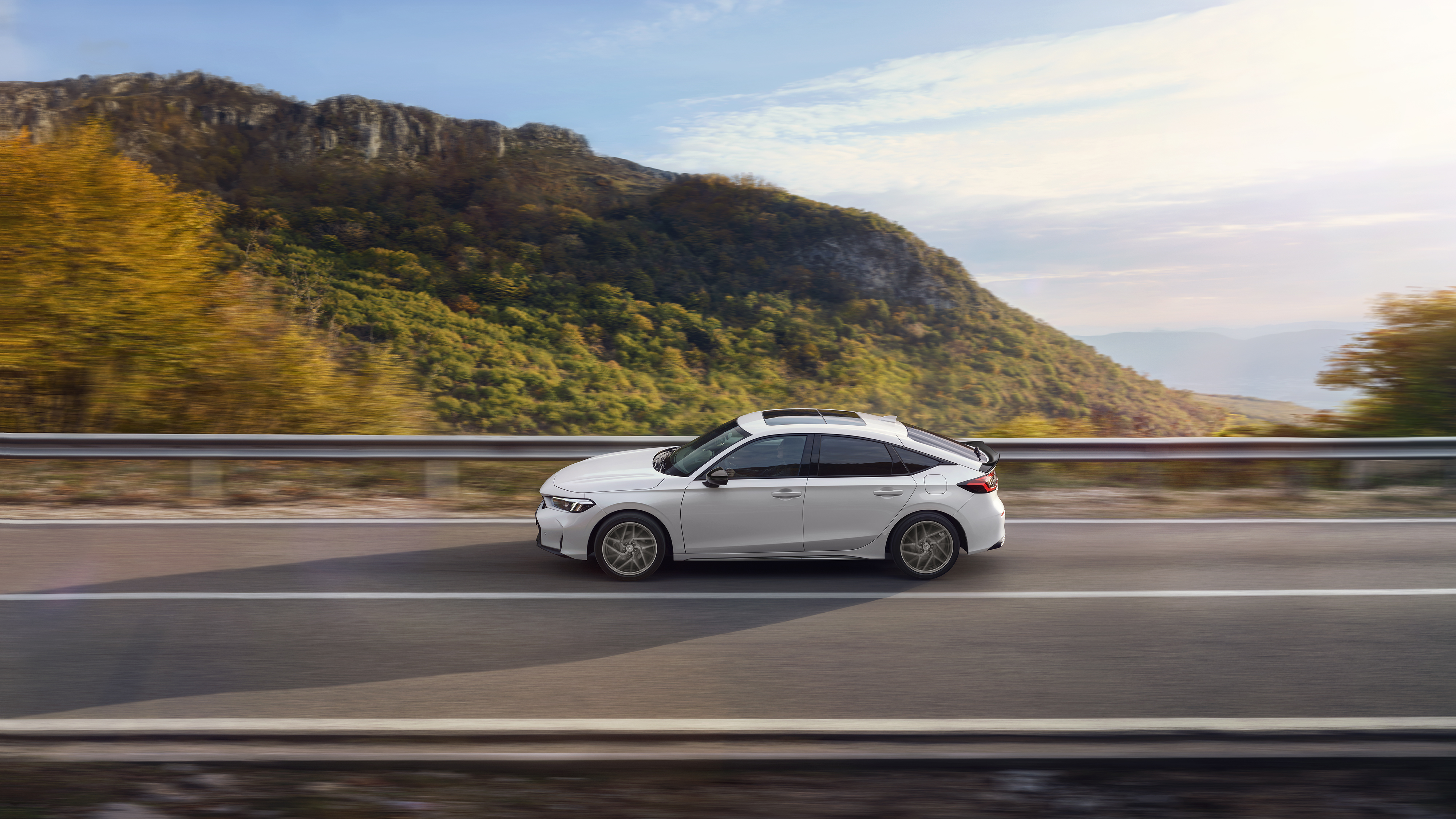 Honda Civic Hybrid en movimiento en una carretera, con una vista panorámica.