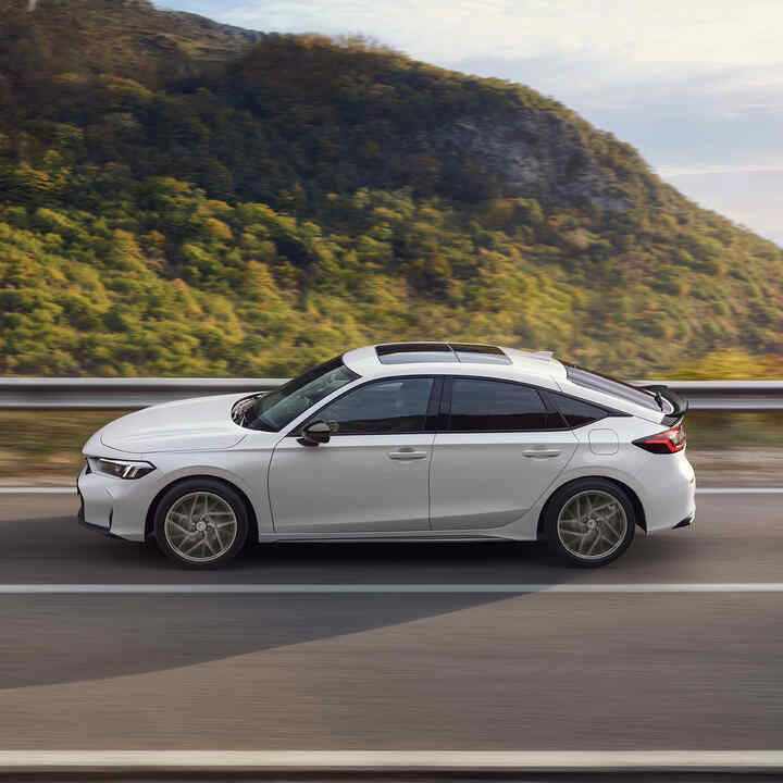 Honda Civic Hybrid en movimiento en una carretera, con una vista panorámica.