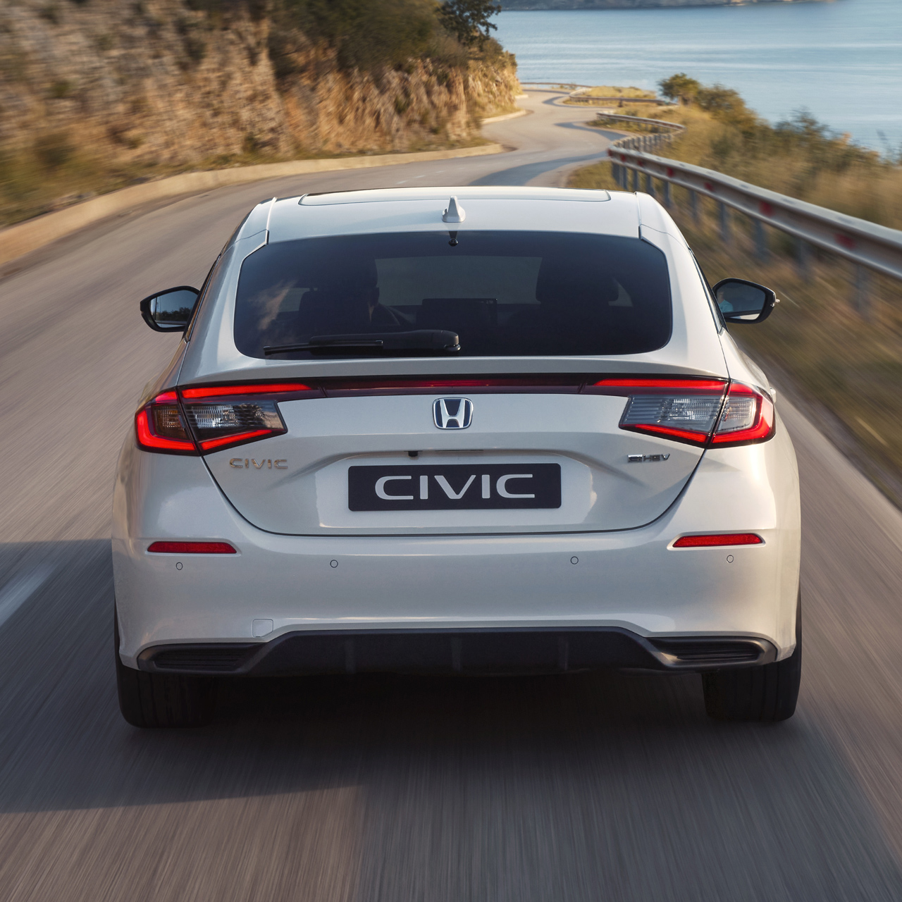 Primer plano de la parte trasera del Honda Civic Hybrid, en movimiento, en una carretera.