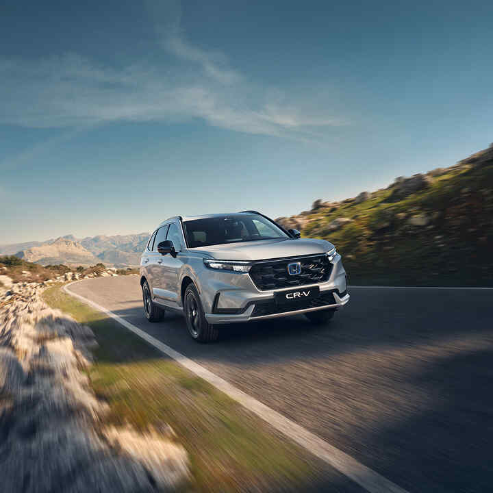 Imagen frontal de tres cuartos del Honda e:Ny1 circulando por la montaña. 