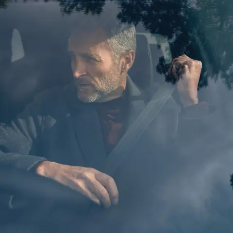 Primer plano de la rueda y el costado del SUV CR-V Híbrido estacionado con el modelo.