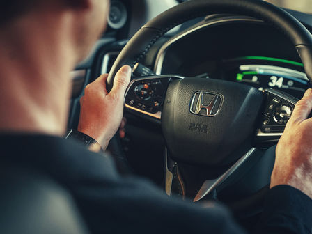 Honda CR-V Híbrido, primer plano de una modelo dentro del coche al volante.