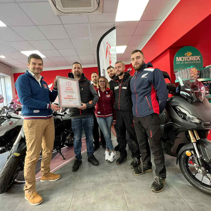 Concesionarios de motocicletas Honda celebrando su premio de reconocimiento.