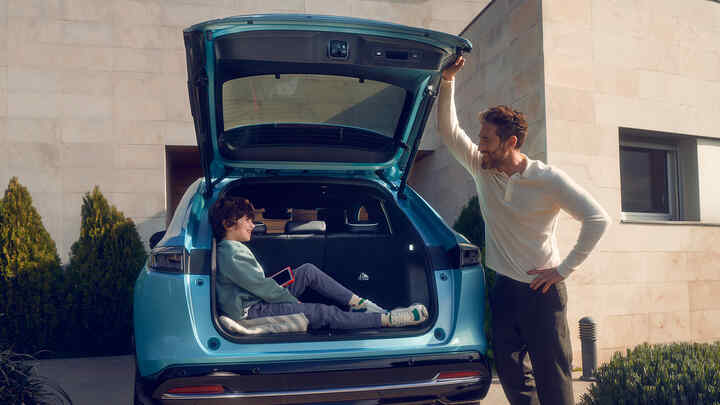 Padre hablando con niño sentado en el maletero del Honda e:Ny1.