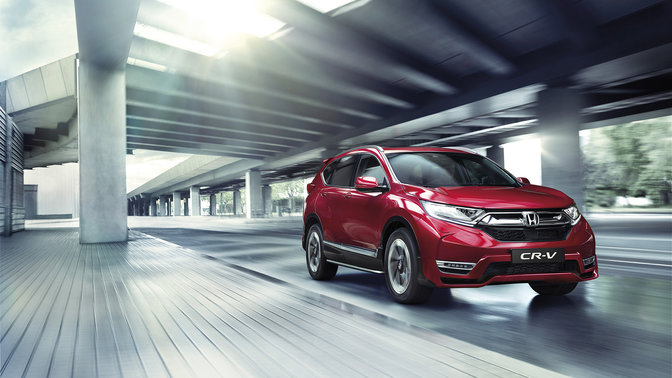Vista frontal del Crossover compacto CR-V de Honda granate circulando bajo un puente