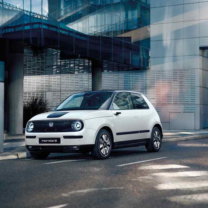 Honda e en la calle con edificios al fondo