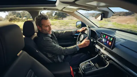 Modelo sentado dentro del CR-V Híbrido usando Honda Sensing 360.