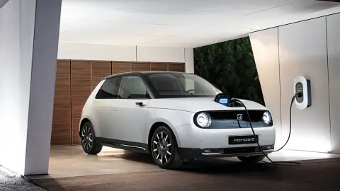 Honda e estacionado y cargando en una residencia privada.