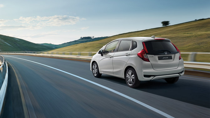 Vista trasera de tres cuartos del Honda Jazz Dynamic, en zona rural.