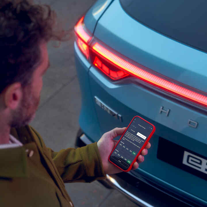 My Honda+ app, primer plano de una persona utilizando un teléfono fuera del coche