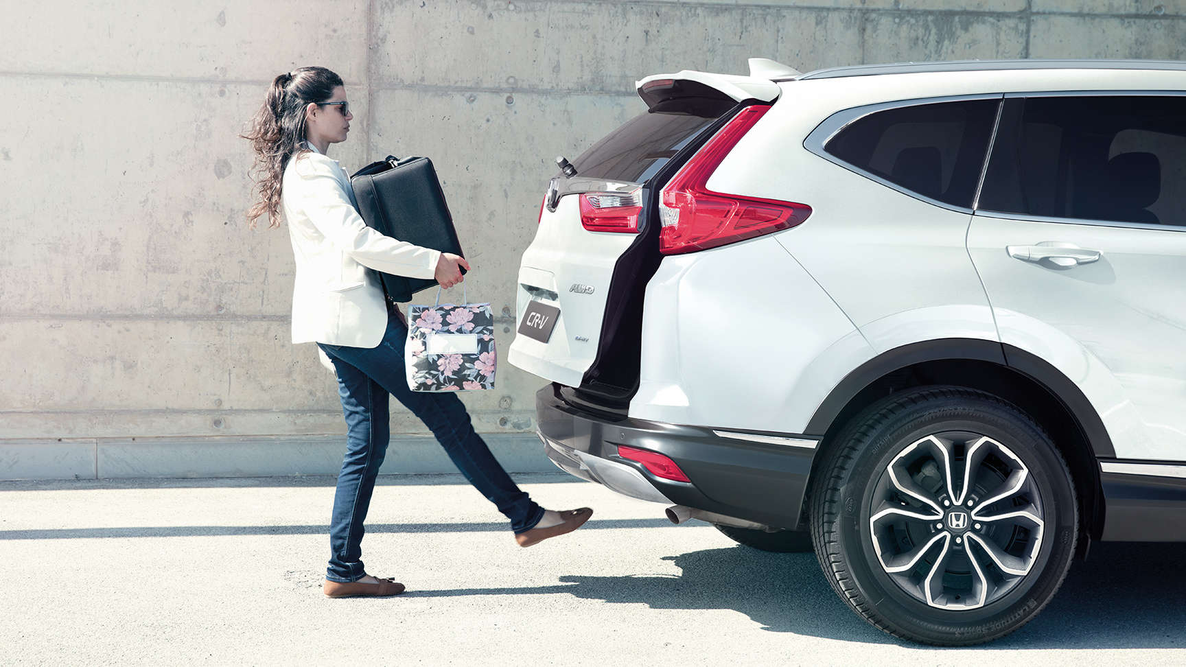 Mujer cargando en la parte trasera de un CR-V
