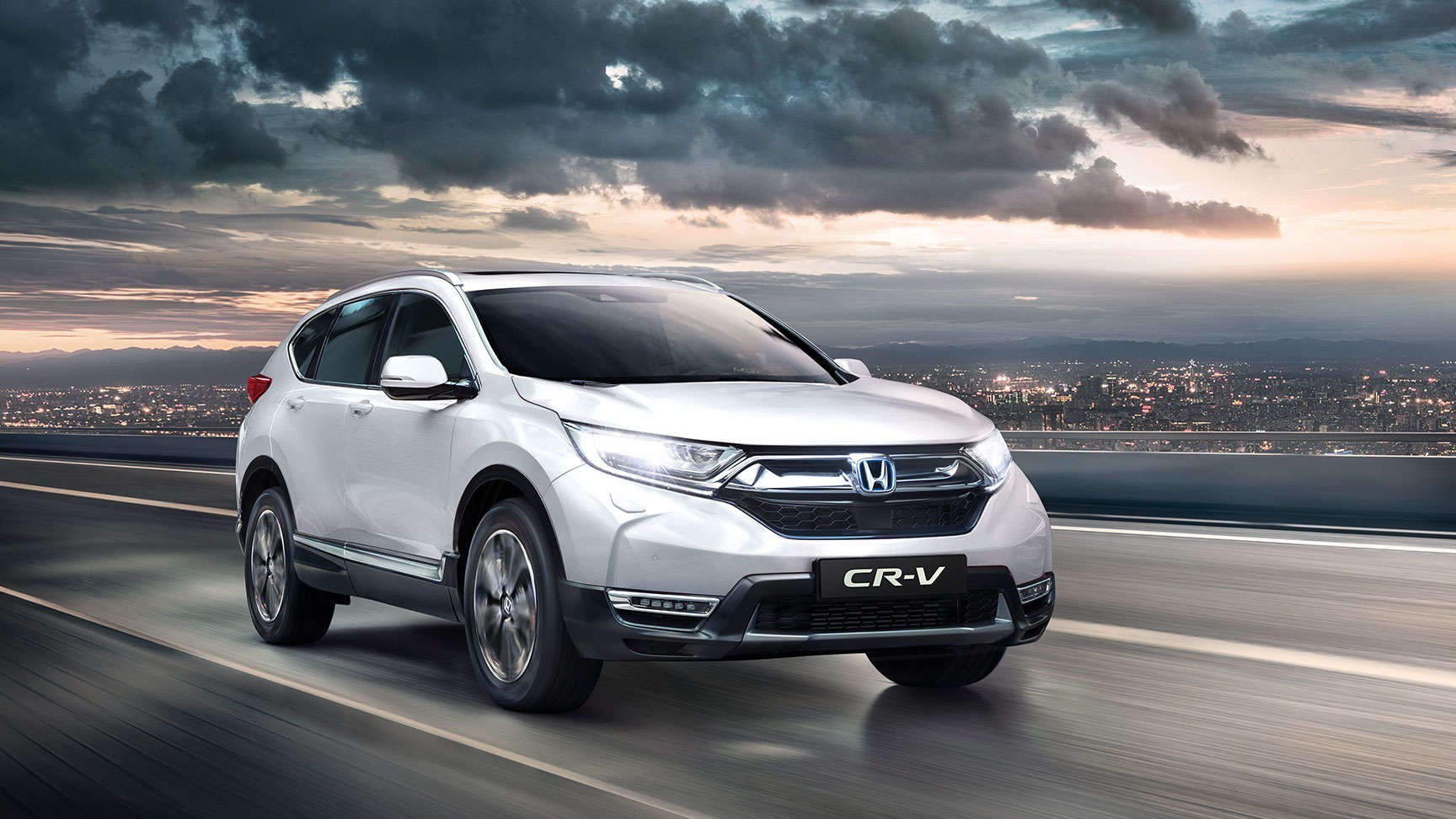Vista frontal de tres cuartos del Honda CR-V con las luces de carretera encendidas