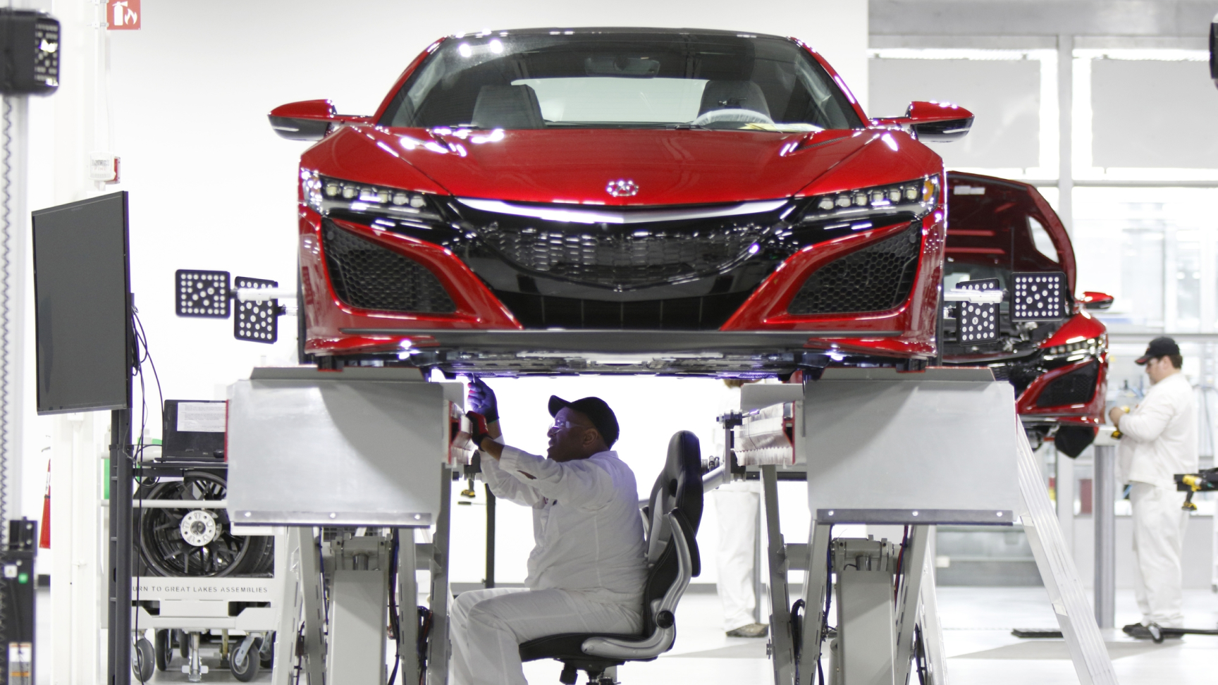 Vista delantera de un NSX con un técnico de Honda trabajando en él.