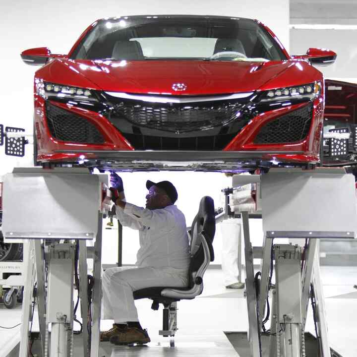 Vista delantera de un NSX con un técnico de Honda trabajando en él.