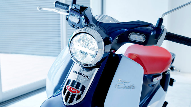 Honda Super Cub aparcada en una zona moderna.
