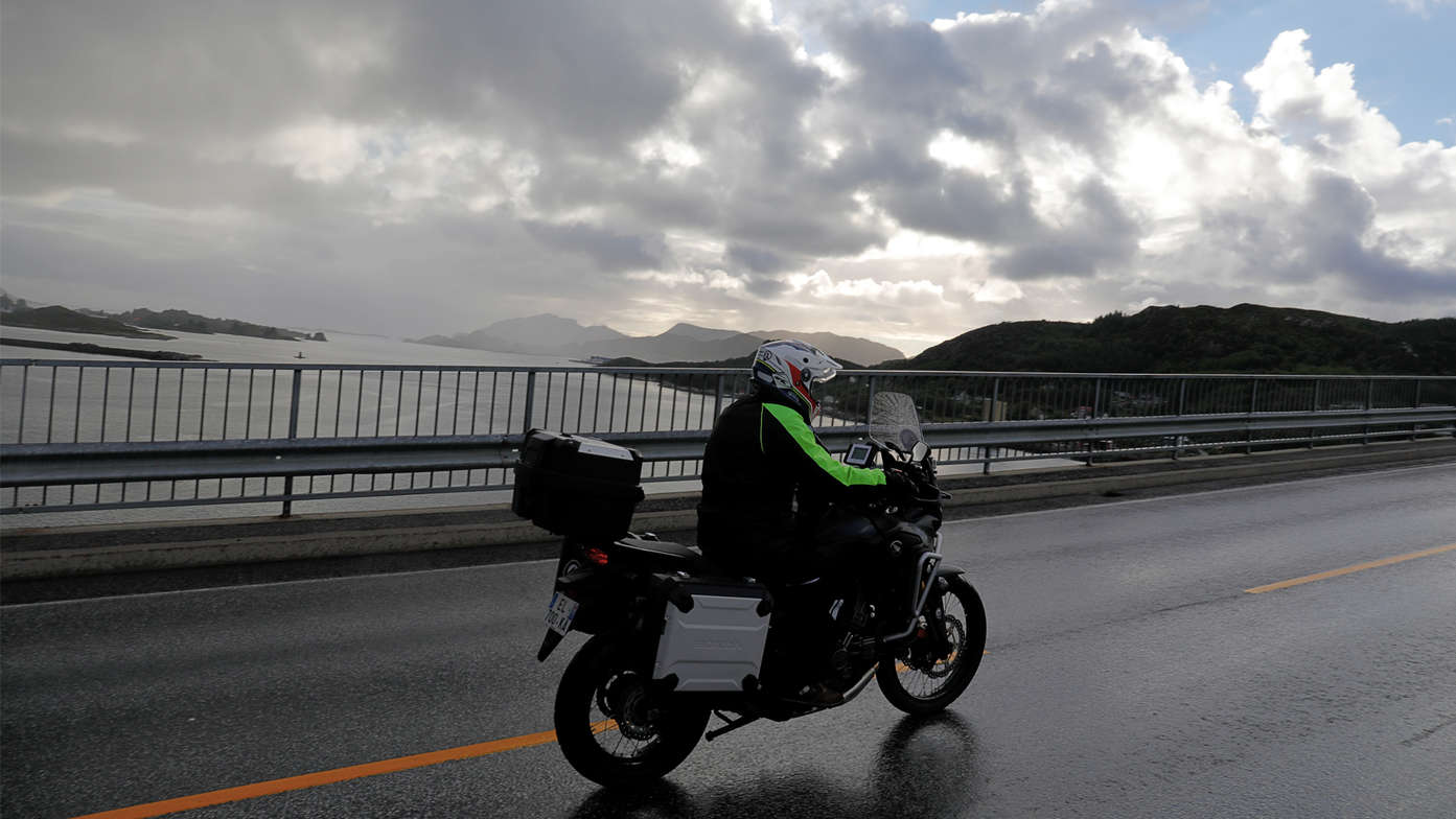 Honda Adventure Roads Nordkapp Dia 1 de Oslo a Fosnavag Africa Twin pasando sobre puente en un lago