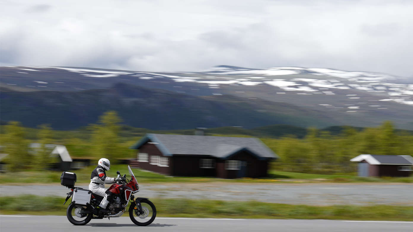 Honda Adventure Roads Nordkapp Dia 1 de Oslo a Fosnavag Africa Twin roja con fondo de montañas nevadas