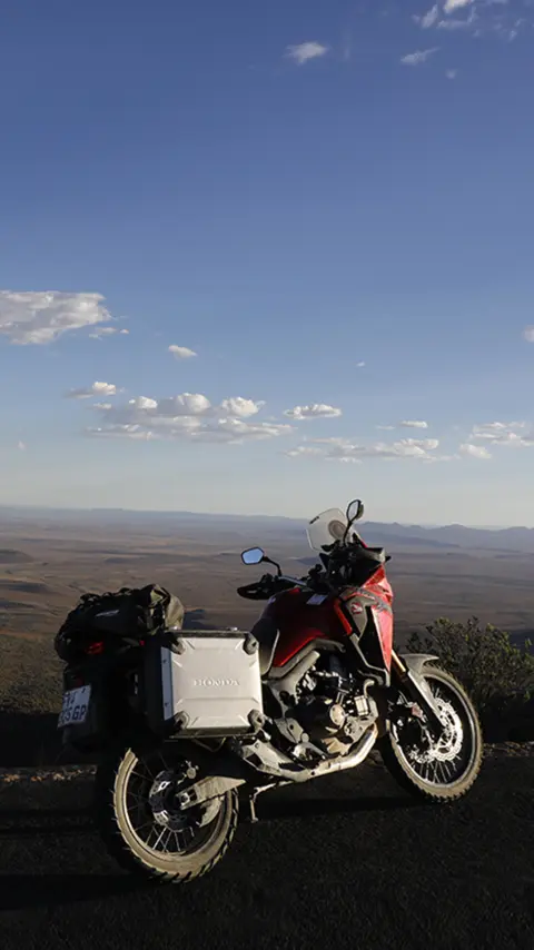 Honda CRF1000L Africa Twin aparcada junto a la carretera, con vistas al desierto del Karoo.