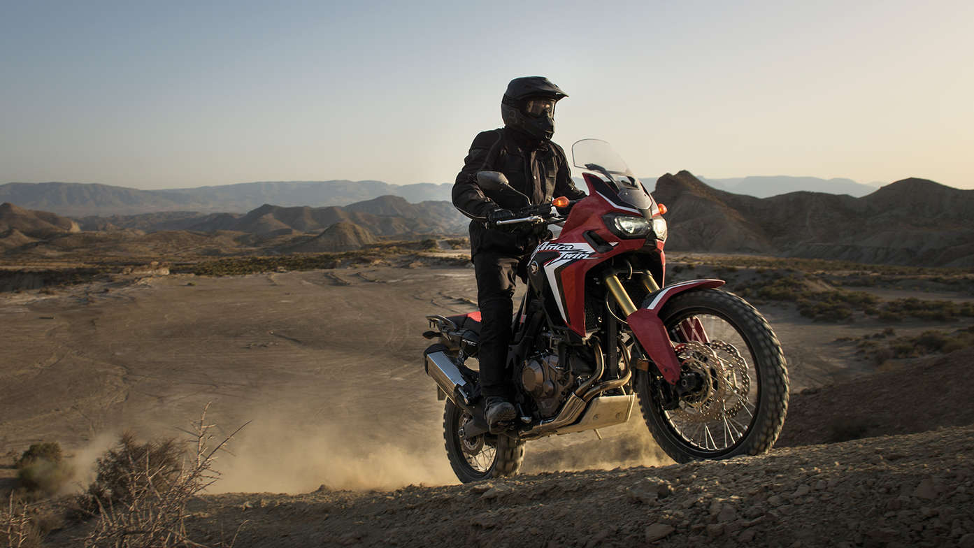 Motorista subiendo una colina en una Africa Twin