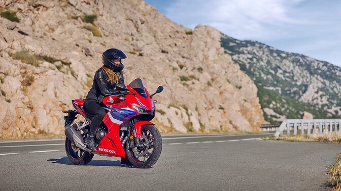 Vista dinámica frontal de tres cuartos de la CB500R con piloto