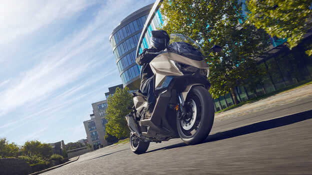 Imagen de tres cuartos de la parte de atrás de la Dax 125 parada junto al mar.