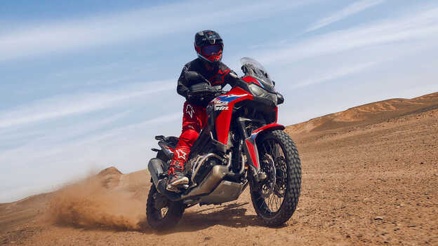 Modelo en moto CRF1100L Africa Twin en lugar desértico.