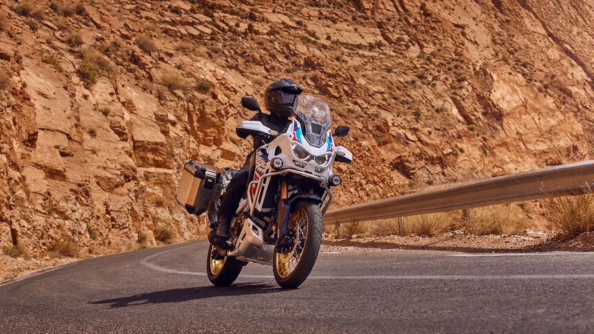 Vista delantera de 3/4 de Honda CRF1100 Africa Twin Adventure Sports en una ubicación montañosa.