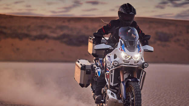 Piloto con Honda CRF1100 Africa Twin Adventure Sports en un lugar desértico.