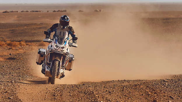 Piloto de frente en Honda CRF1100 Africa Twin Adventure Sports en un lugar desértico.