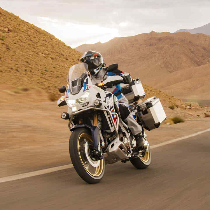 Piloto con Honda CRF1100 Africa Twin Adventure Sports en un lugar desértico.