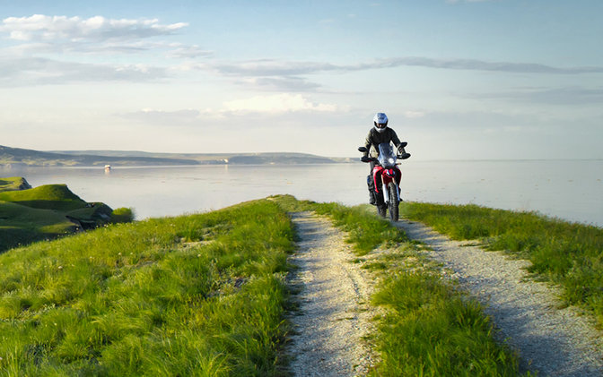 CRF250 Rally con piloto en carretera costera
