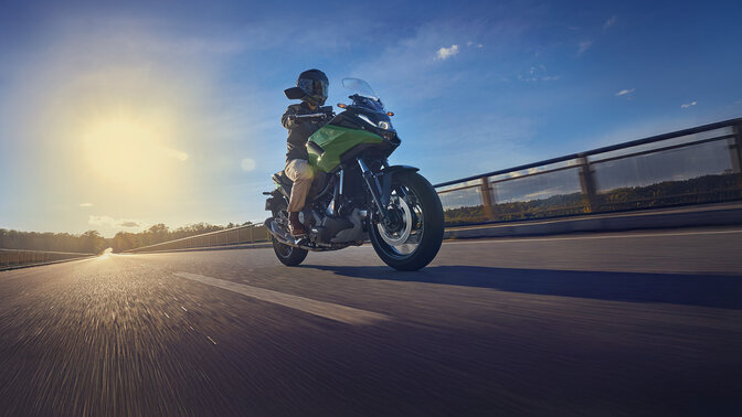 Modelo conduciendo la motocicleta NC750X por una carretera.