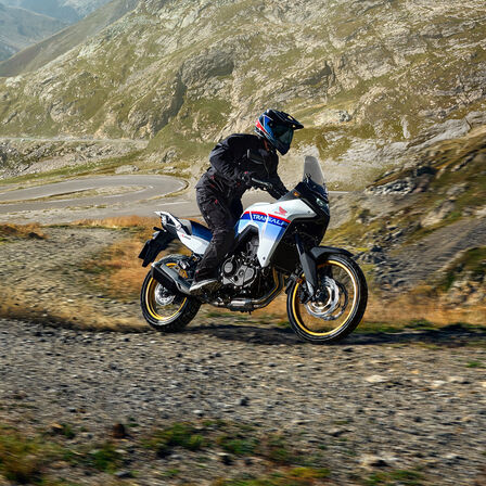 XL750 Transalp en pista de tierra frente a las montañas.