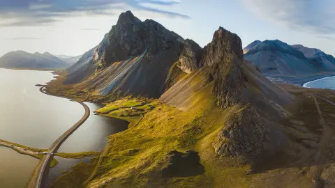 Carretera pintoresca en Islandia, hermoso paisaje natural, panorama aéreo, montañas y costa al atardecer