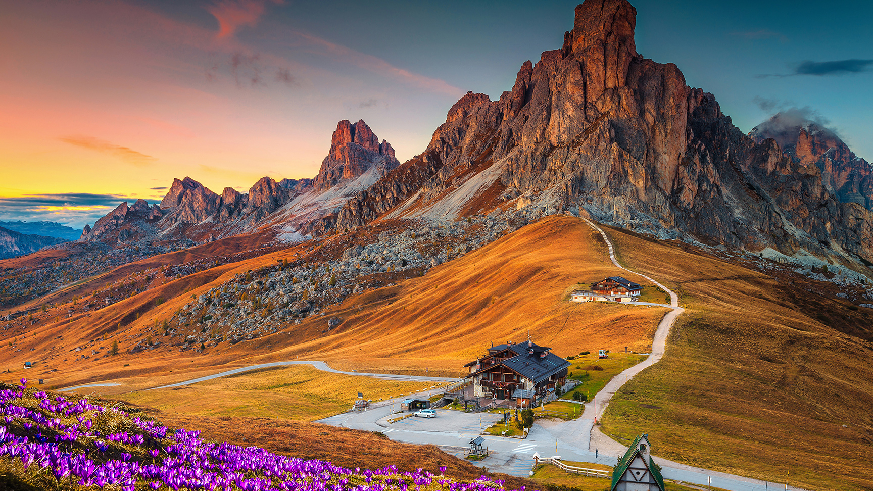 Maravilloso paisaje alpino con flores de azafrán de primavera en la colina y montañas espectaculares al atardecer, el puerto de Giau en los Dolomitas (Italia)