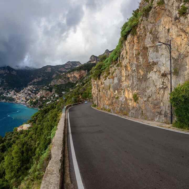 Carretera pintoresca sobre acantilados rocosos y paisaje montañoso junto al mar Tirreno. Costa de Amalfi en Positano (Italia). Viaje de aventura. Vista panorámica