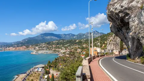 Carretera pintoresca bajo un cielo azul a lo largo de la costa del mar Mediterráneo en la frontera franco-italiana.