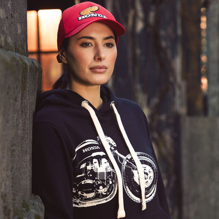 Mujer con sudadera y gorra Honda vintage. 