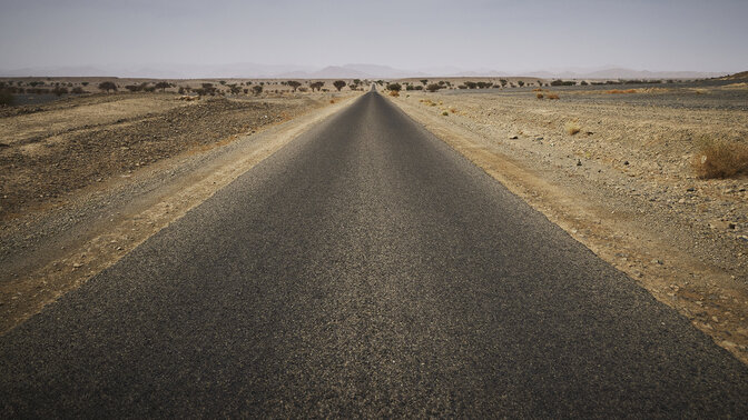 Larga carretera marroquí rodeada de desierto. 