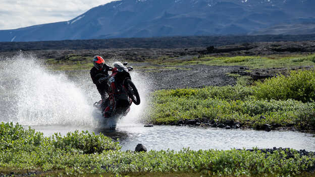 Kiran Mirabet montando en una Africa Twin a través del agua. 