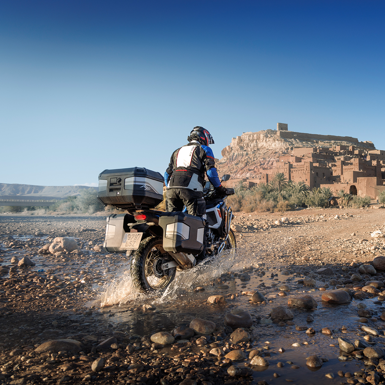 Piloto en una CRF1100 ATAS orientada hacia atrás con accesorios de touring.