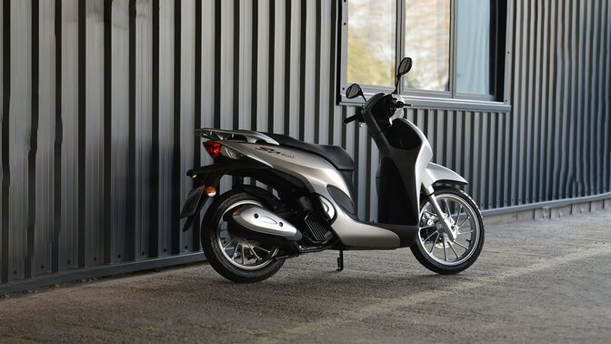 Vista trasera de 3/4 de la Honda SH Mode 125 en carretera