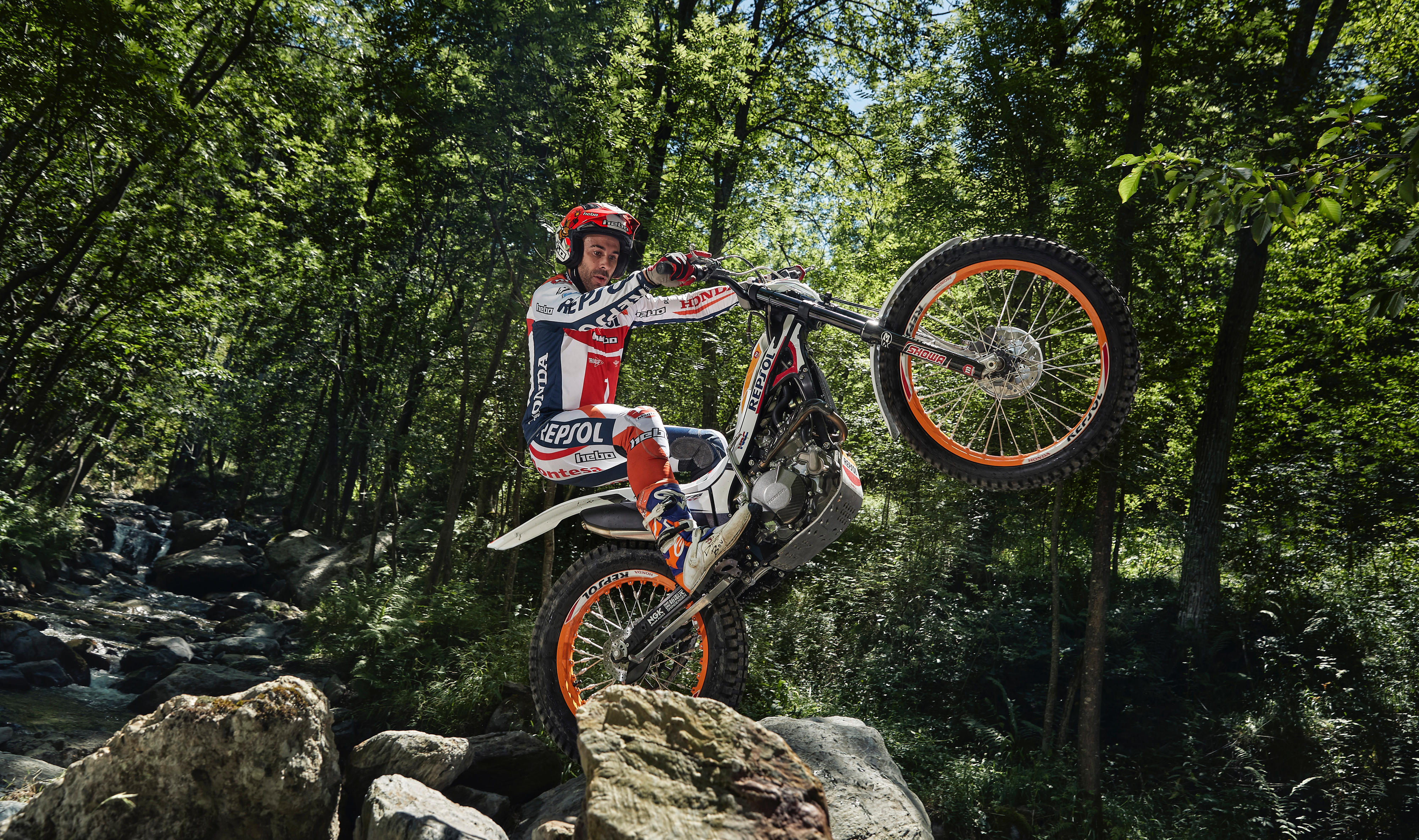 Montesa 4RT Race Replica, lateral delantero derecho de tres cuartos, en un paisaje montañoso