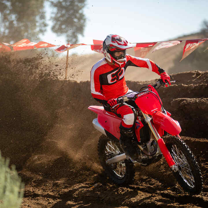 Honda CRF450R conducida fuera de la carretera con montañas de fondo.