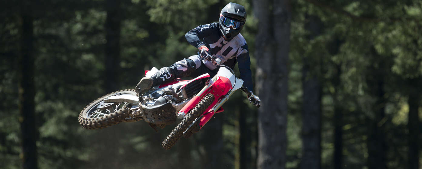 Vista frontal de la motocicleta CRF450R saltando, con piloto.