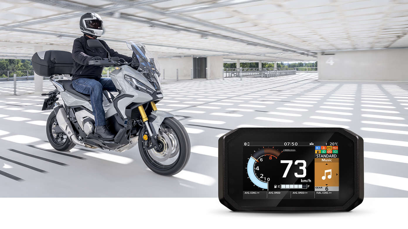 Honda X-ADV, lateral derecho con conductor en carretera en un parking, música