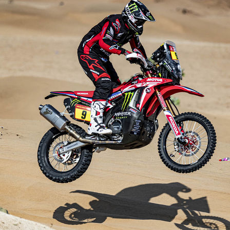 Piloto del equipo Honda Dakar en una motocicleta en el desierto.