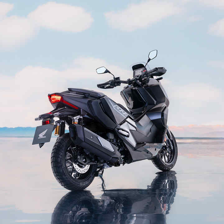 Vista trasera 3/4 de la Honda ADV350 en ubicación costera. 